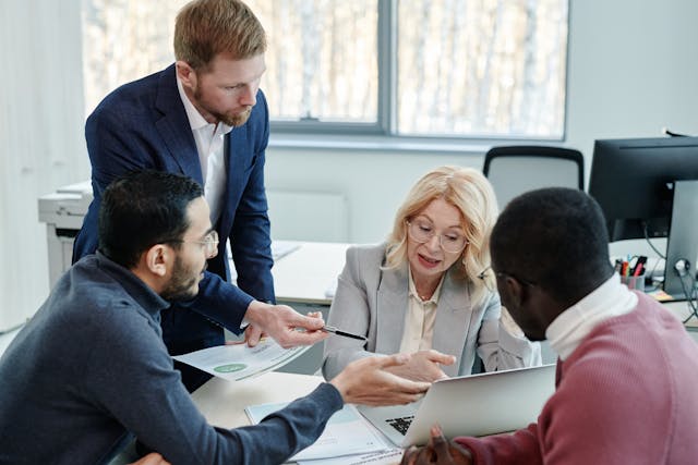 Pessoas conversando sobre trabalho em abiente formal.